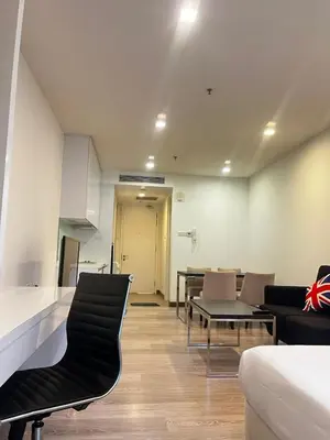 a living room with chairs and a table and a kitchen at Flexy Suite at One Bukit Ceylon Bukit Bintang in Kuala Lumpur