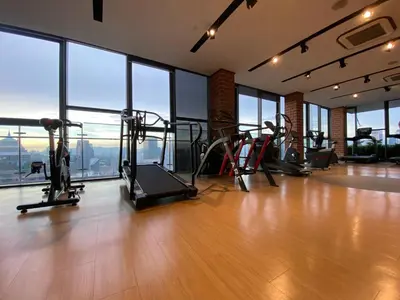 a gym with cardio equipment in a building with windows at Ceylonz Suites by Stayla in Kuala Lumpur