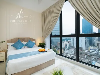 a bedroom with a bed with a large window at Majestic Residence - Central KL Stay with Petronas Twin Towers View Sky Pool by The Stay Hub in Kuala Lumpur