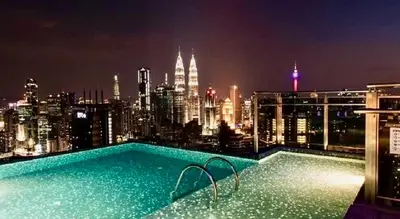 a swimming pool on top of a building with a city skyline at KLCC Expressionz Couple Suites 1B1B in Kuala Lumpur