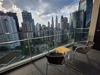 a balcony with a table and chairs and a city skyline at SS Luxury Suites AT TM Persiaran Stonor KLCC in Kuala Lumpur