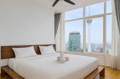 a bedroom with a large white bed with a large window at Sky Suites KLCC - Luxury Service Apartments Near Petronas Twin Tower in Kuala Lumpur