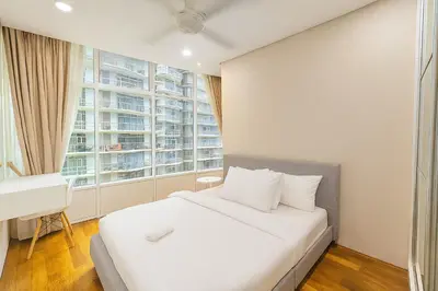 a bedroom with a bed and a desk and a window at Sky Suites KLCC - Luxury Service Apartments Near Petronas Twin Tower in Kuala Lumpur