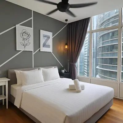 a bedroom with a white bed and a large window at Sky Suites KLCC - Luxury Service Apartments Near Petronas Twin Tower in Kuala Lumpur