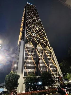 a tall building is lit up at night at Scarletz Villa Near By KLCC in Kuala Lumpur