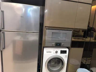 a refrigerator and a washing machine in a kitchen at Dorsett Luxury Residence KL in Kuala Lumpur