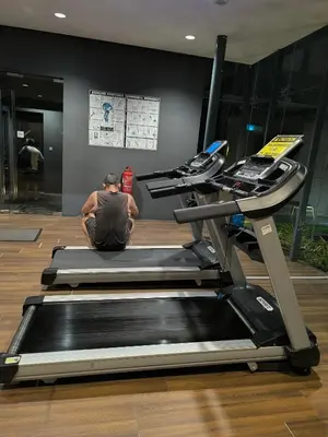 a man sitting on a treadmill in a gym at Dorsett Luxury Residence KL in Kuala Lumpur