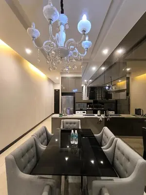 a dining room with a table and a chandelier at Dorsett Luxury Residence KL in Kuala Lumpur