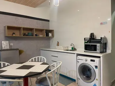 a kitchen with a table and a washing machine at Arte Ampang KLCC 2 BR Homestay, 4-6 pax in Ampang