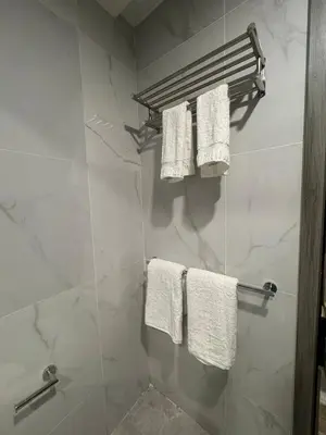 a bathroom with white towels hanging on a wall at Deluxe Duplex Studio Suite at Agile Bukit Bintang in Kuala Lumpur