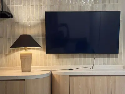 a table with a lamp and a television on a wall at Deluxe Duplex Studio Suite at Agile Bukit Bintang in Kuala Lumpur