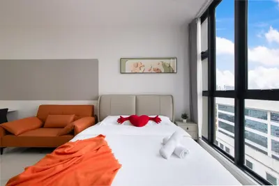 a bedroom with a bed and a couch and a window at Majestic by Avery at KLCC#Located in the City Center#10 mins Walk to Twin Towers#Rooftop Infinity pool#\u4e2d\u82f1\u6587\u623f\u4e1c in Kuala Lumpur