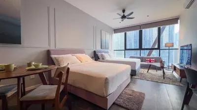 a hotel room with two beds and a desk and a table at Scarletz Suite KLCC By Light House 3 in Kuala Lumpur