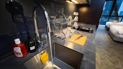a kitchen counter with a sink and a dish drying rack at Scarletz Suite KLCC By Light House 3 in Kuala Lumpur