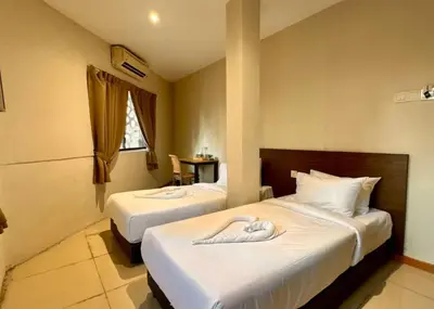 two beds in a hotel room with towels on them at Swing & Pillows - Chow Kit Road, Kuala Lumpur in Kuala Lumpur