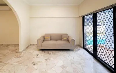a couch in a room with a large window at Damansara Heights Luxury Villa with Private Pool in Kuala Lumpur