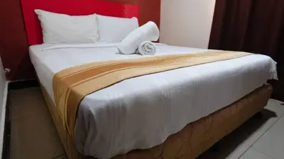 a bedroom with a large bed with a red headboard at Hotel Wings Kuala Lumpur in Kuala Lumpur