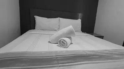 a black and white photo of a bed with two towels at Hotel Wings Kuala Lumpur in Kuala Lumpur