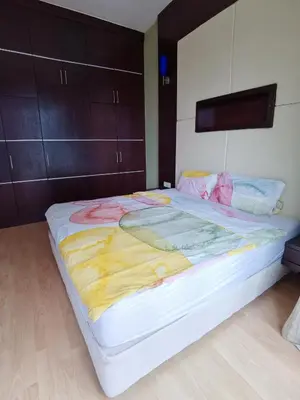 a large white bed in a room with wooden floors at Seri Bukit Ceylon By S&S in Kuala Lumpur