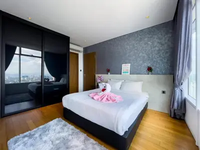 a bedroom with a bed with a pink dress on it at The Luxury Penthouse KLCC in Kuala Lumpur