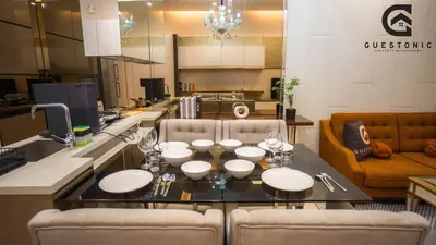 a kitchen with a dining table with chairs and a couch at Dorsett Residences Bukit Bintang by Guestonic in Kuala Lumpur