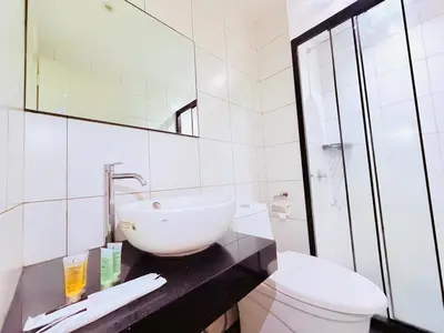 a white bathroom with a sink and a toilet at Chamber Luxury Serviced Suites KL in Kuala Lumpur