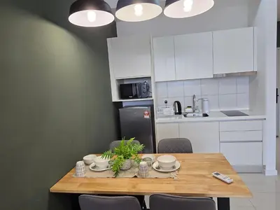 a kitchen with a wooden table with chairs and appliances at GRAND Suites Chamber AT Klcc in Kuala Lumpur