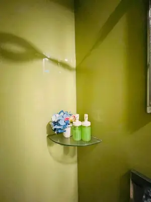 a shelf with three candles and flowers on a wall at Votrex Suites KLCC By Classic Home in Kuala Lumpur