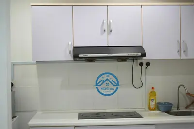 a kitchen with white cabinets and a microwave above a stove at Binjai 8 Premium Soho by Heaven Stay in Kuala Lumpur