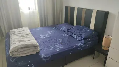 a bed with a blue comforter on top of it at Legasi Kampong Bharu in Kuala Lumpur