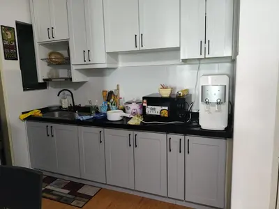 a kitchen with white cabinets and a counter top at Legasi Kampong Bharu in Kuala Lumpur