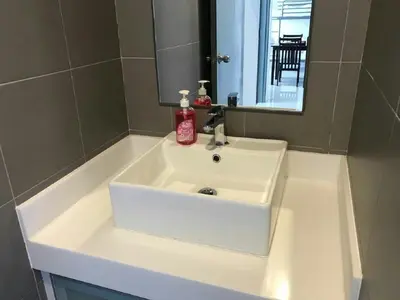 a white sink in a bathroom with a mirror at Summer Suites Studios in Kuala Lumpur