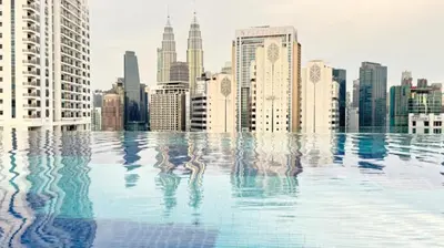 a swimming pool with a city skyline in the background at Majestic Residences KLCC By Cozy in Kuala Lumpur