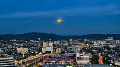 a view of a city with a moon in the sky at The Elements Ampang A place of Tranquility Premium in Kuala Lumpur
