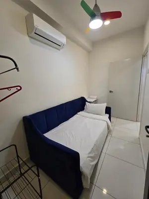 a blue bed in a room with a ceiling fan at RuangWaktu at Arte Mont Kiara in Kuala Lumpur