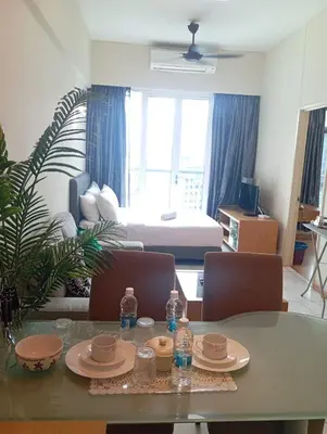 a living room with a table and chairs with water bottles at Sky suite at Seri Bukit Ceylon in Kuala Lumpur
