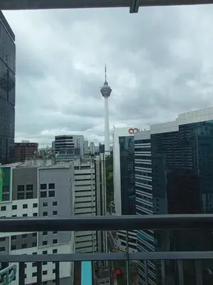 a view of a city with a tower in the background at Sky suite at Seri Bukit Ceylon in Kuala Lumpur