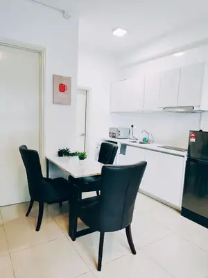 a kitchen with a table and chairs and a refrigerator at Arte Plus by Stay Relax in Kuala Lumpur