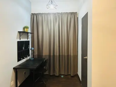 a room with a desk and a computer in front of a curtain at V Residence Suites, Sunway Velocity by Rasbo Galaxy Suites in Kuala Lumpur