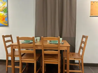 a wooden table with two chairs and a table with plates at V Residence Suites, Sunway Velocity by Rasbo Galaxy Suites in Kuala Lumpur
