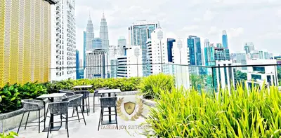 a balcony with tables and chairs and a city skyline at Kuala Lumpur Luxury Suites By Majestic Residence in Kuala Lumpur