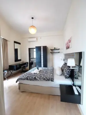 a bedroom with a large bed and a couch at Seri Bukit Ceylon apartment in Kuala Lumpur