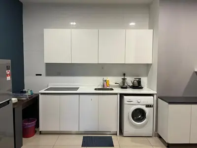 a kitchen with white cabinets and a washing machine at Jom Relax in Kuala Lumpur