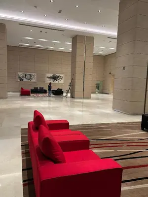 a red couch sitting in a large room at KLCC Marc Residence by AZ Line in Kuala Lumpur