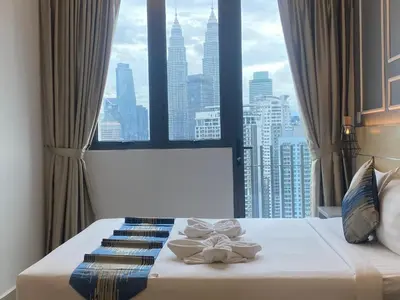 a bed in a room with a large window at The Colony By Infinitum KLCC - Aura Suites in Kuala Lumpur