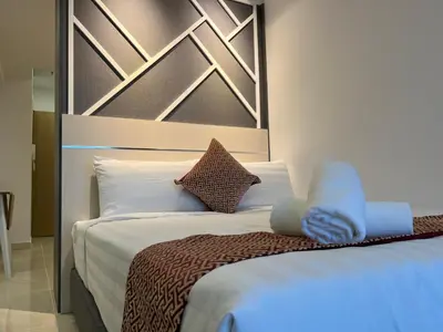 a bedroom with a bed with white sheets and pillows at The Colony By Infinitum KLCC - Aura Suites in Kuala Lumpur