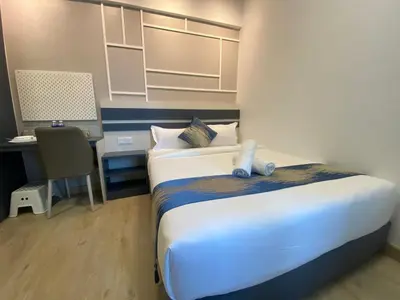 a hotel room with a bed and a desk and a bed sidx sidx at The Colony By Infinitum KLCC - Aura Suites in Kuala Lumpur