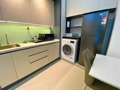 a kitchen with a washing machine and a washer at The Colony By Infinitum KLCC - Aura Suites in Kuala Lumpur