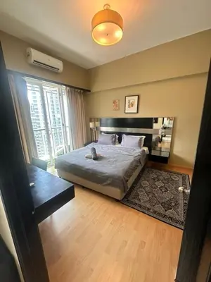 a bedroom with a bed and a large window at AL Seri Bukit Ceylon in Kuala Lumpur