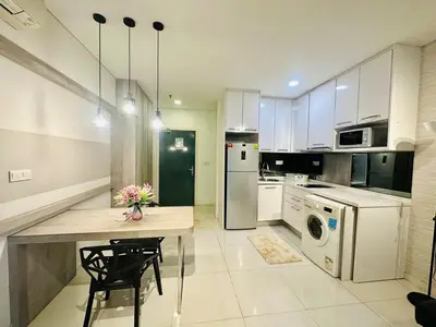 a kitchen with white appliances and a table with flowers on it at Studio Apartment KLCC Area in Kuala Lumpur